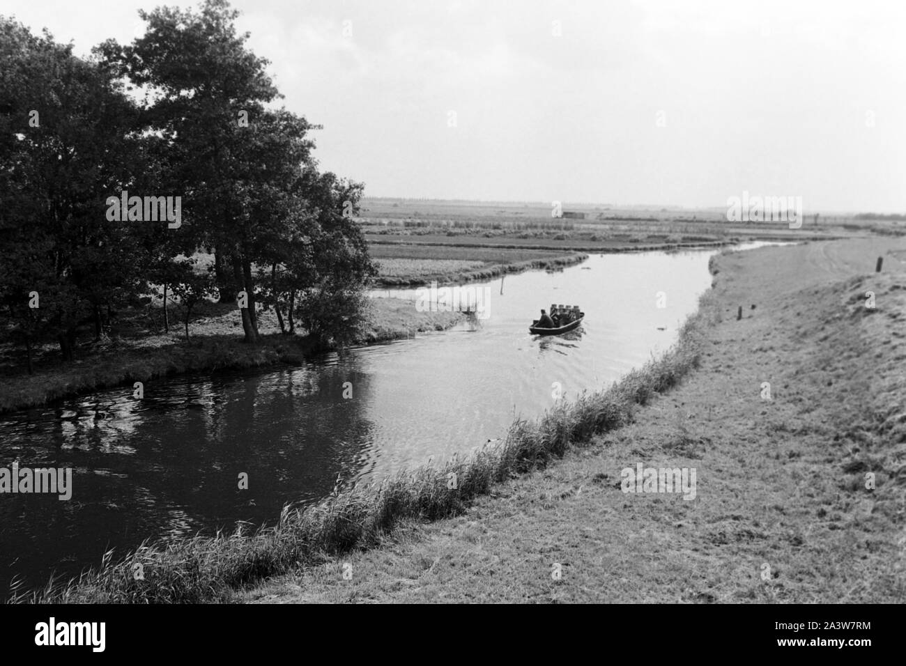 Männer durchfahren die Landschaft in der Provinz Noord-Holland mit einem Kahn, Niederlande 1971. Men on a boat on a canal in the Noord-Holland province, The Netherlands 1971. Stock Photo