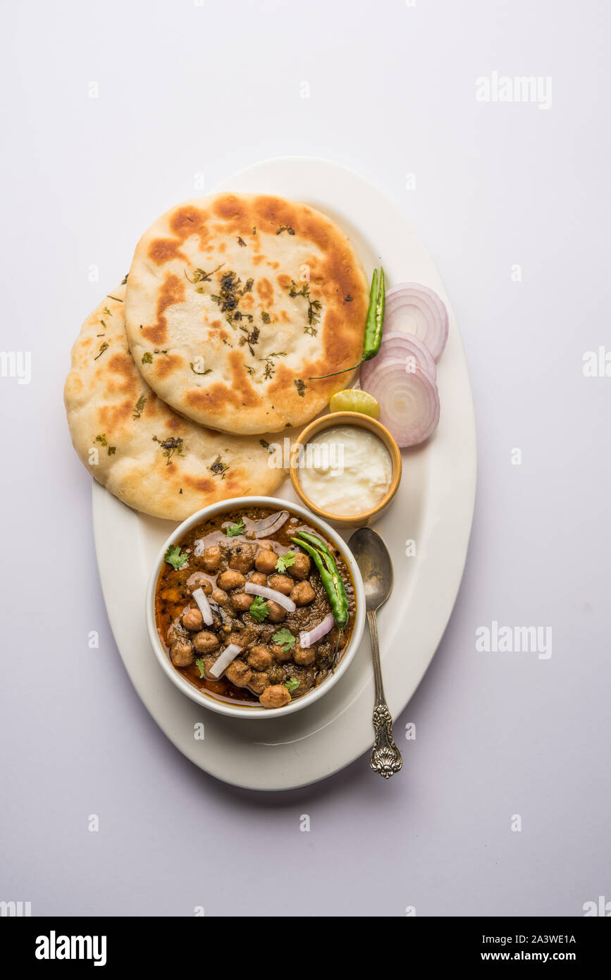 Pindi Chole Kulche or roadside choley Kulcha popular in India and pakistan is a popular streetfood. It's a spicy Chickpea or chana curry served with I Stock Photo
