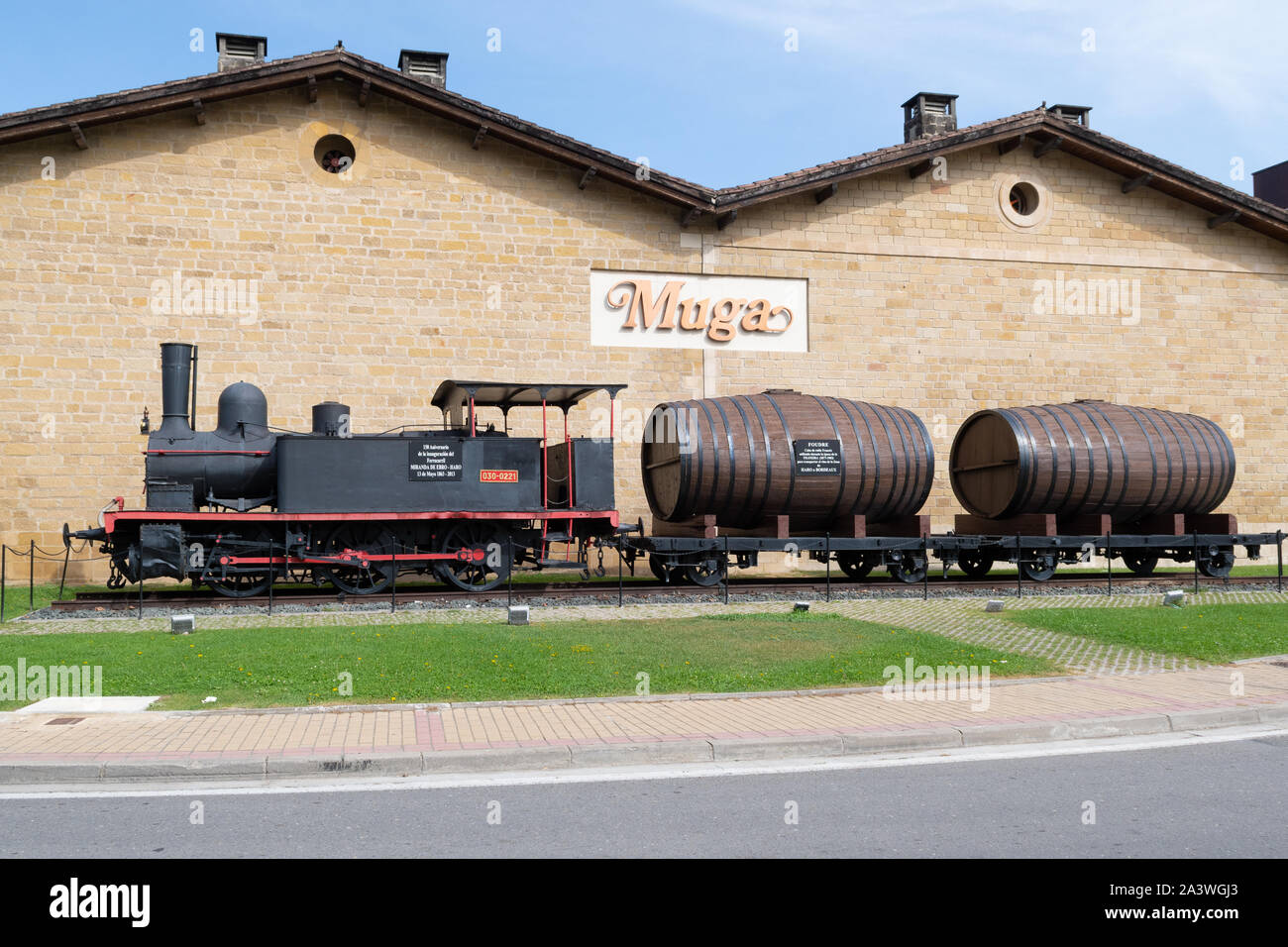 Vintage locomotive and oak barrels in front of Bodegas Muga or winery, in Haro Station . District, Haro, La Rioja, Spain Stock Photo