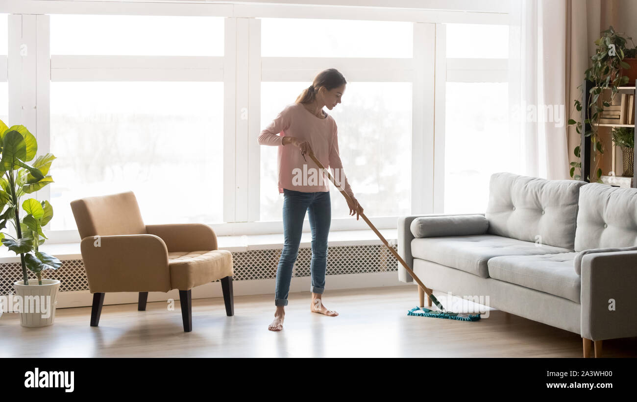 Young woman housewife clean floor in modern living room Stock Photo