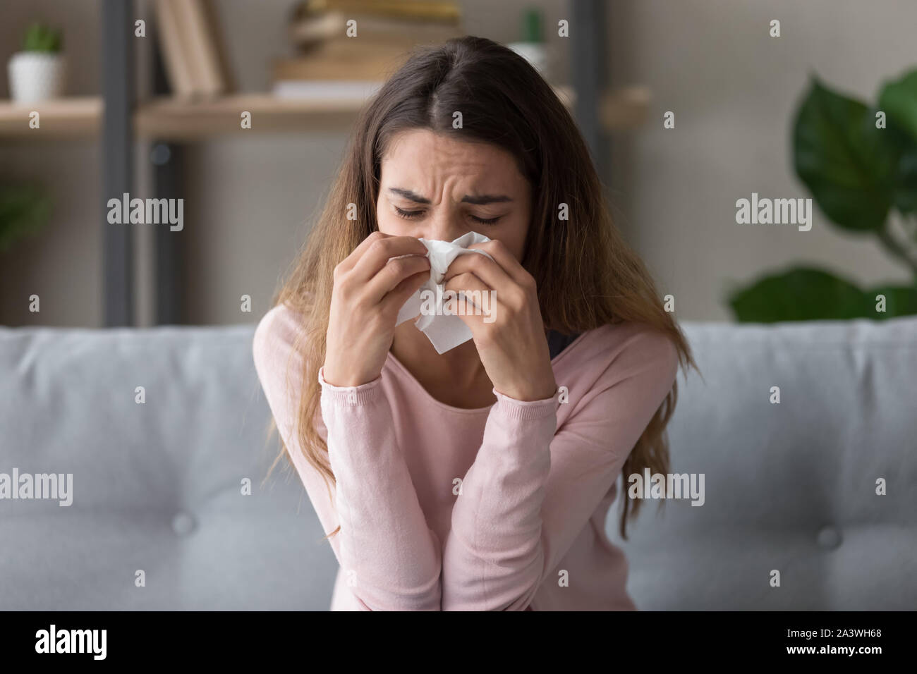 Allergic ill woman holding tissue blowing running nose Stock Photo