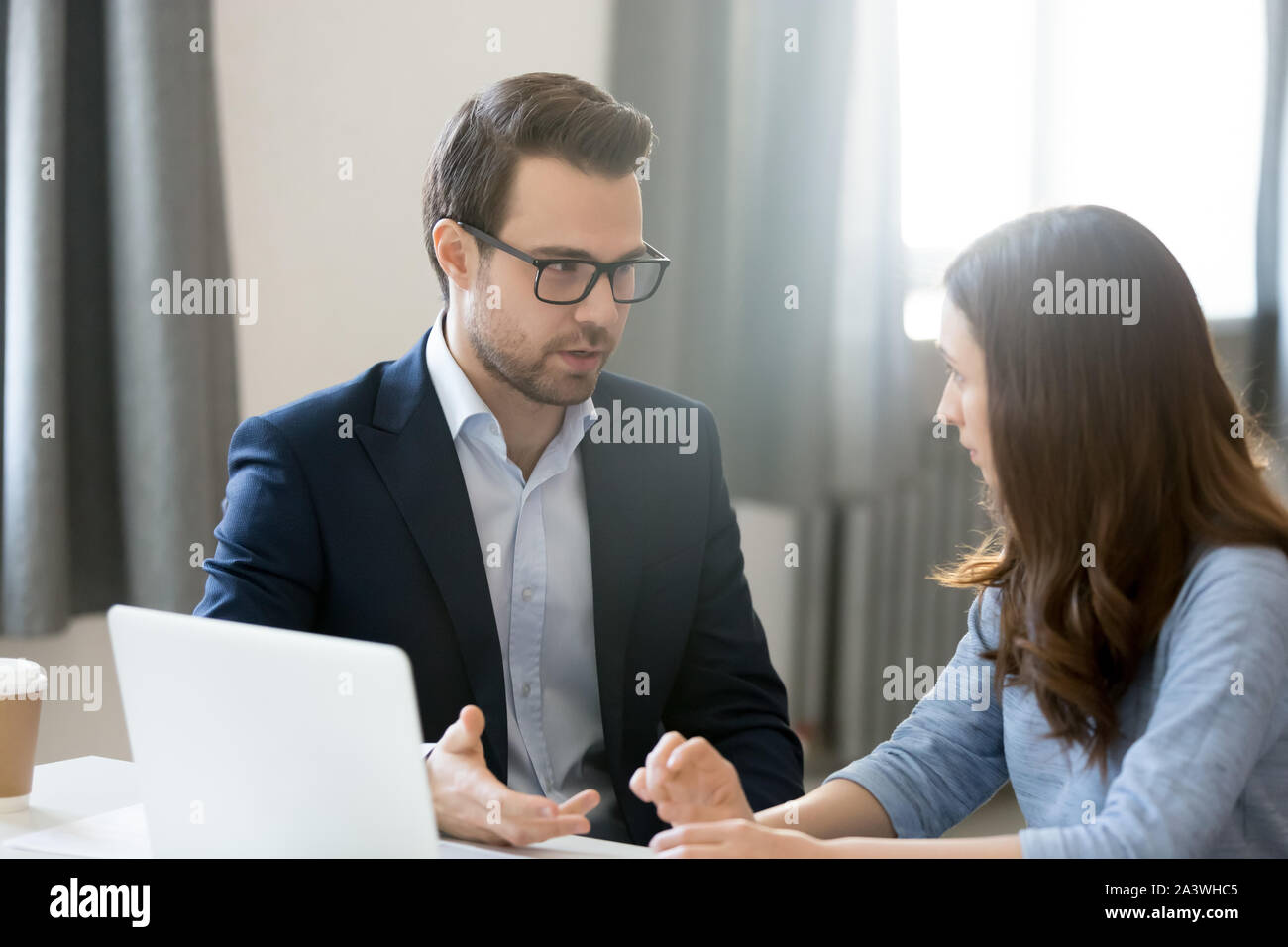 Company members woman man sitting at desk discussing new project Stock Photo