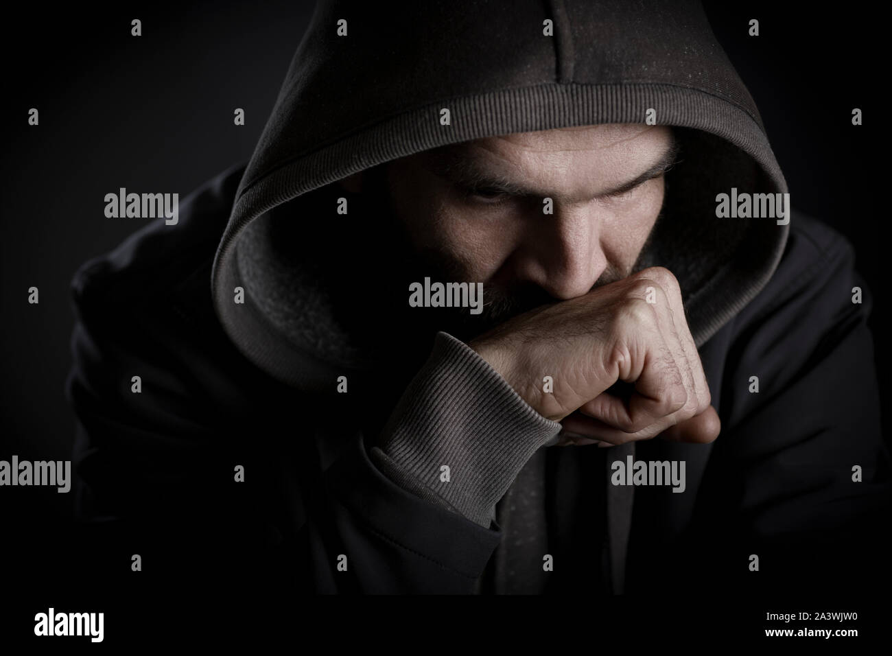 Thoughtful man with hood looking worried. Stock Photo