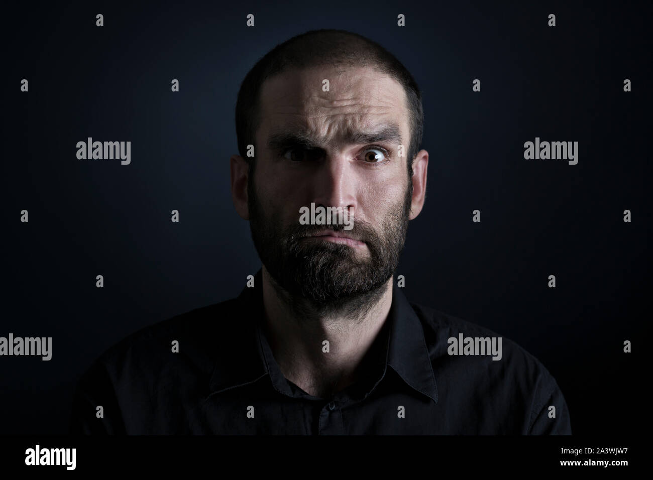Portrait of confused man on black background Stock Photo - Alamy