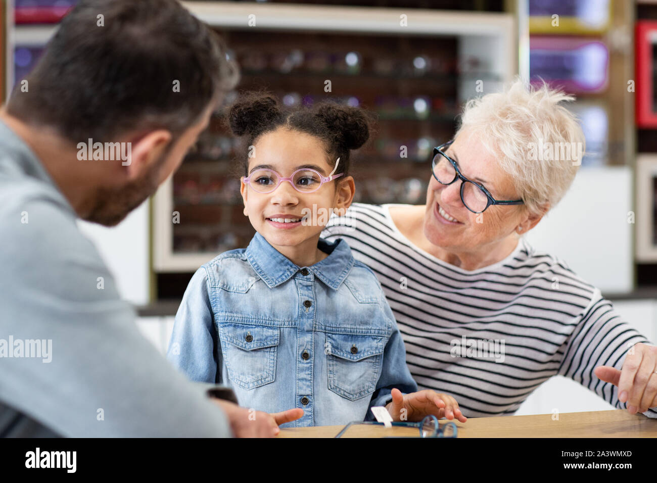 Young girl choosing glasses at the optician Stock Photo