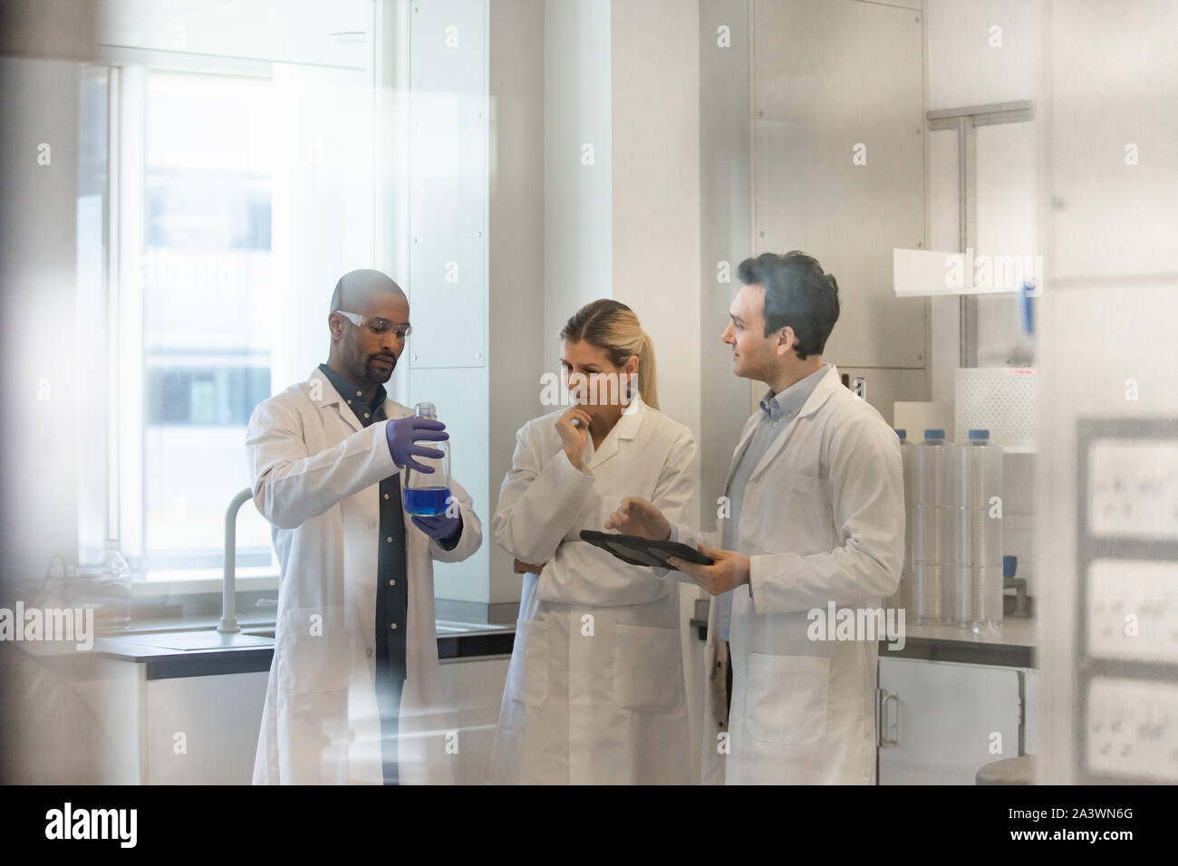 Team of scientists discussing experiment data on digital tablet Stock Photo