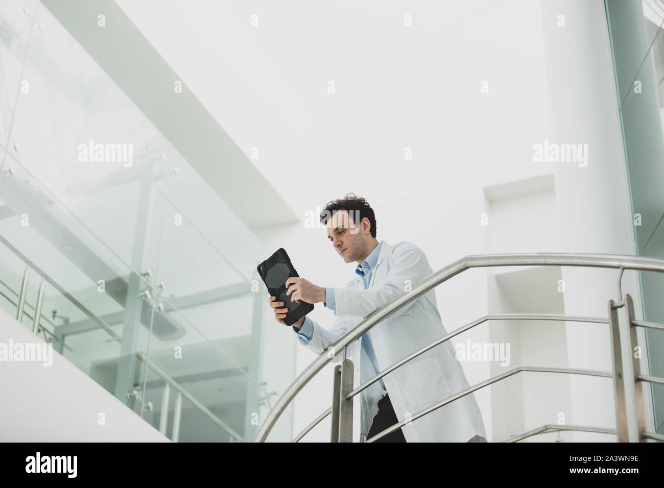 Male Doctor in Hospital looking at test results on a digital tablet Stock Photo