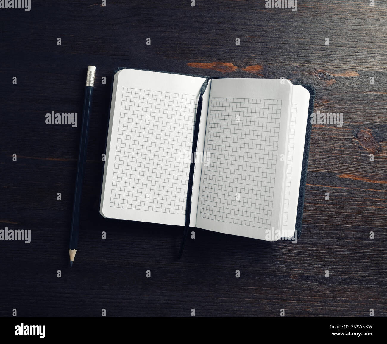 Opened blank notepad and pencil on wooden background. Flat lay. Stock Photo