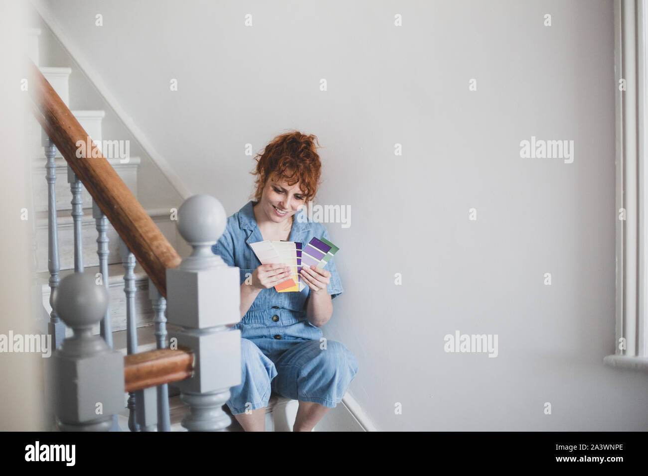 Mid adult female choosing paint colors Stock Photo