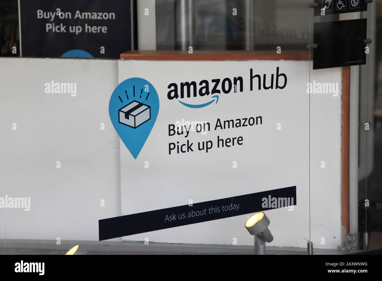 Amazon Hub pick up sign inside a shop window advertising where to pick up your amazon parcels, 2019 Stock Photo