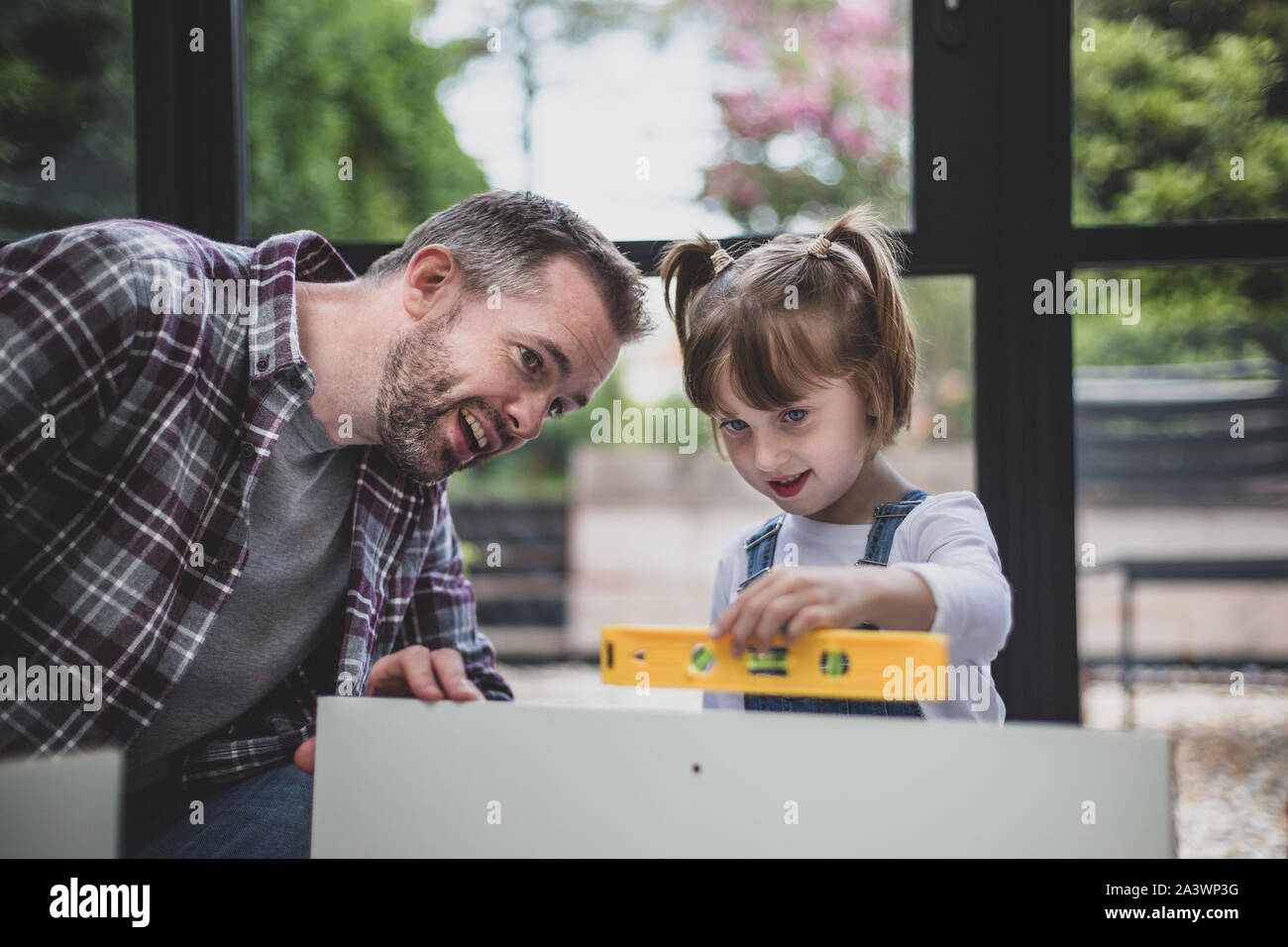 Father teaching Daughter how to use a spirit level Stock Photo