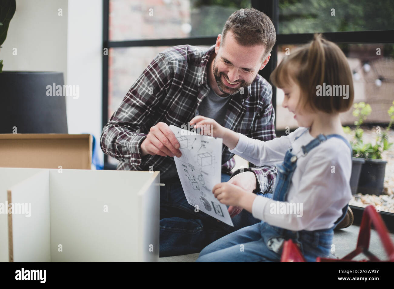 Daughter helping Father with flat pack furniture Stock Photo