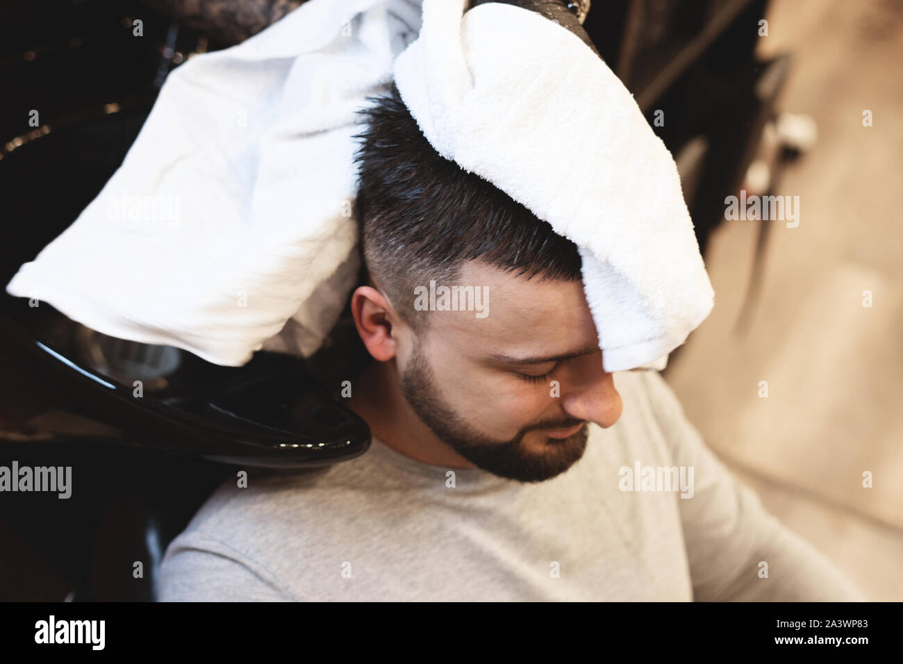 In a a man is washed his hair. Barber washes his client