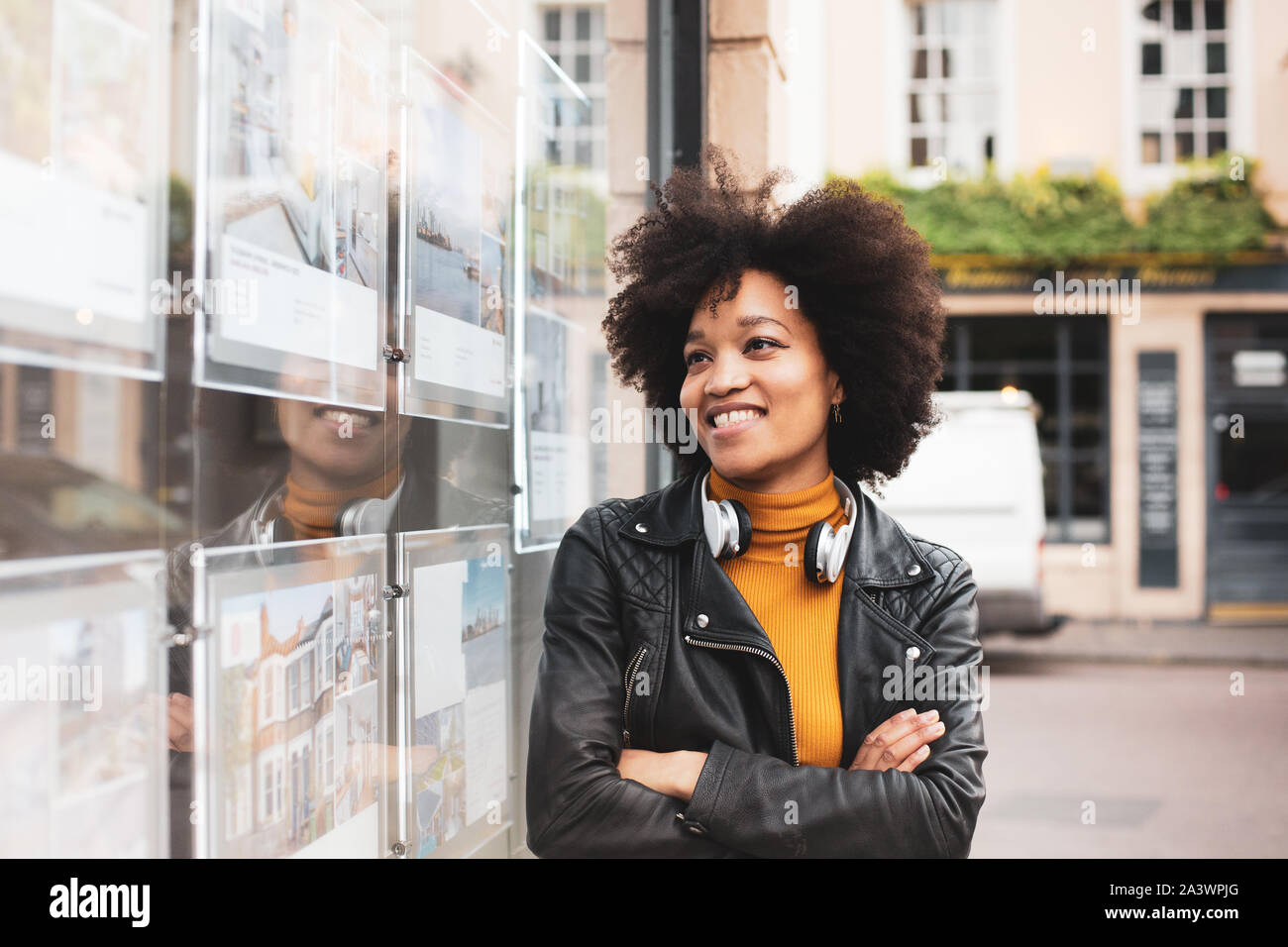 Young adult african american looking at estate agents window Stock Photo