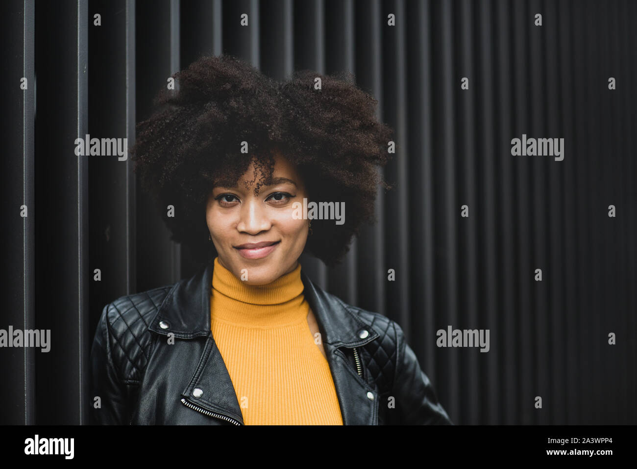 Portrait of African American young adult female with black background Stock Photo