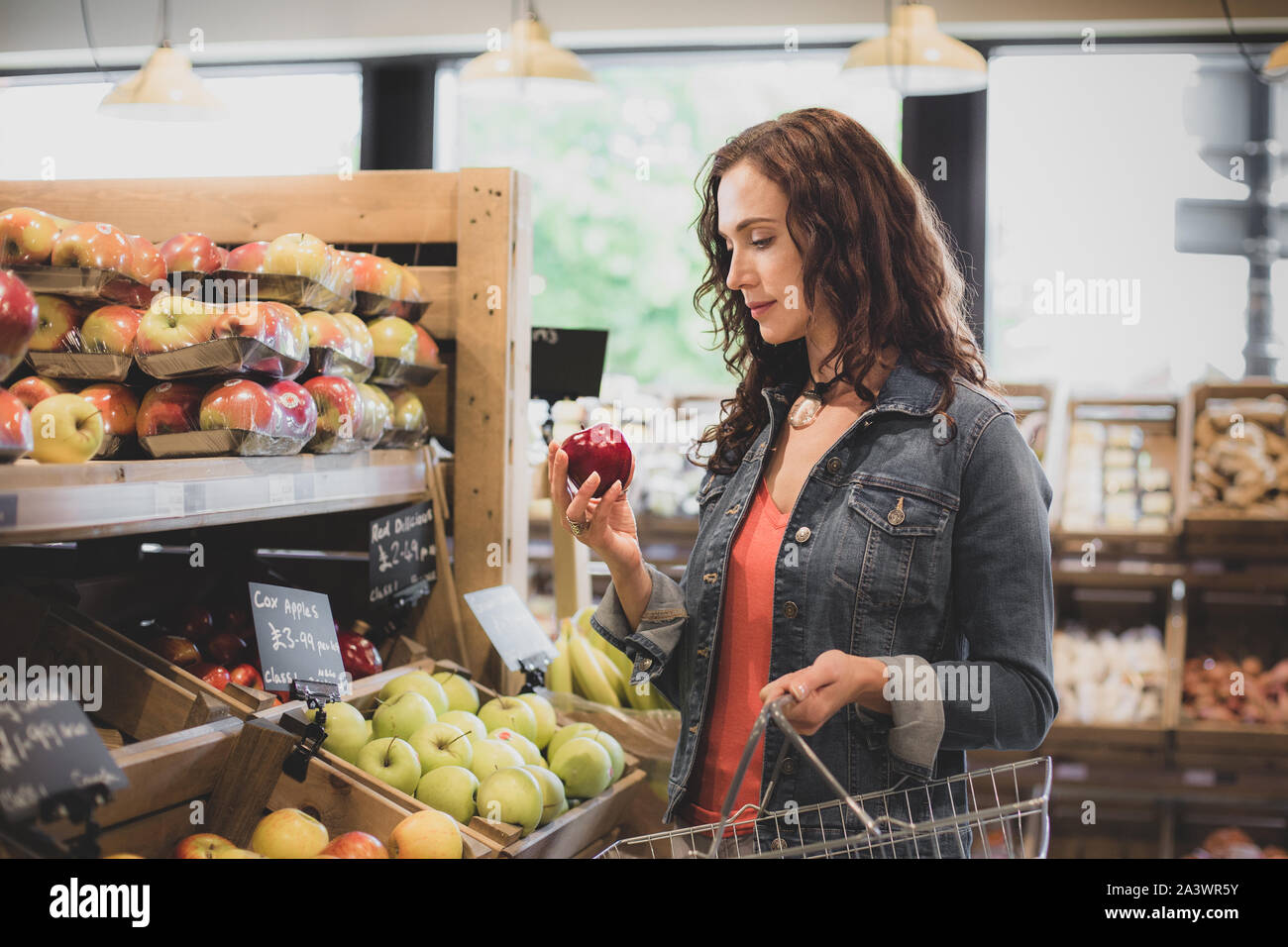 Female shopper buying apples in a grocery store Stock Photo