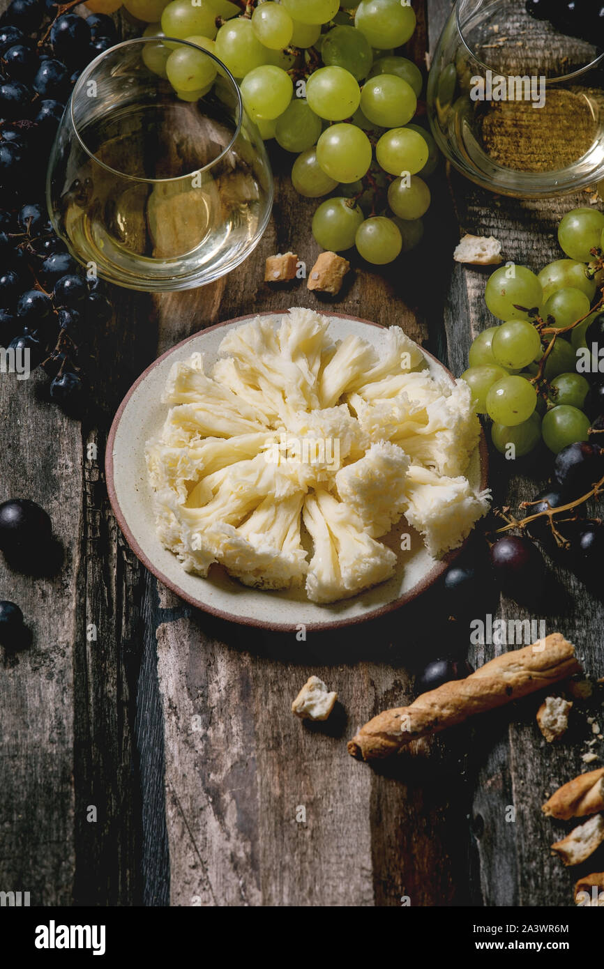 Traditional tete de moine aged mountain cheese of the Alps served with  grapes and walnuts wooden design board with copy space Stock Photo - Alamy