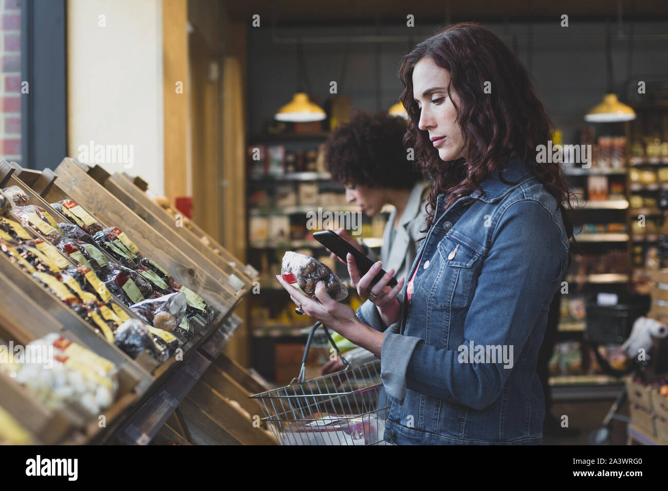 Young adult female using self scan in a grocery store Stock Photo
