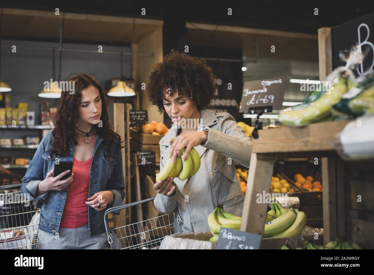 Young adult females food shopping in a grocery store Stock Photo