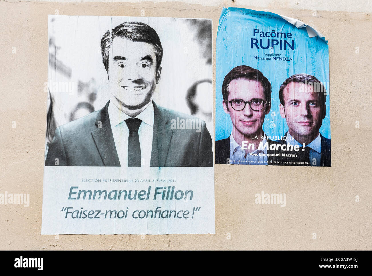 faded posters of 2017 french presidential elections showing francois fillon, emmanuel macron and pacome rupin Stock Photo