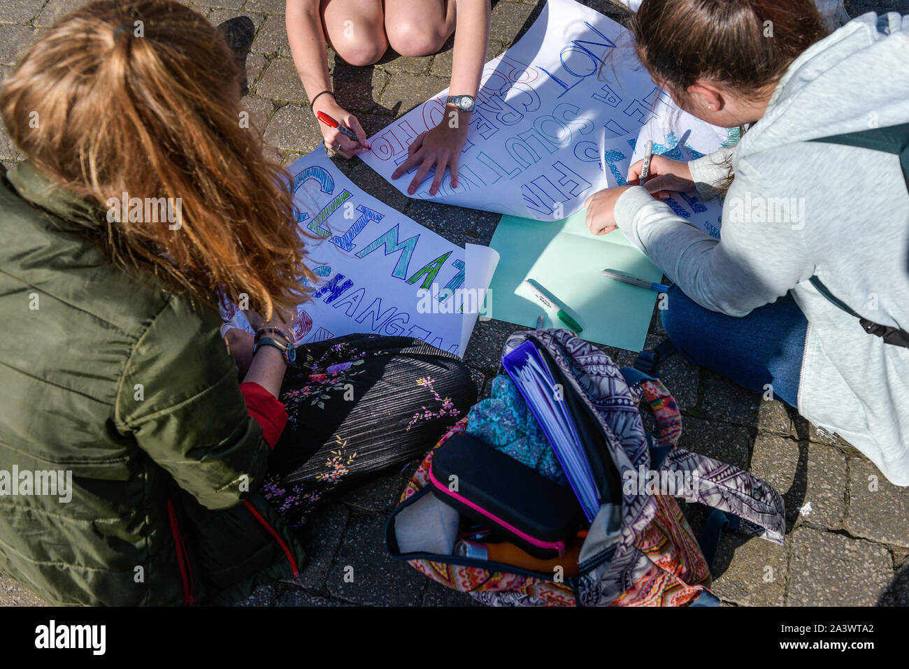 Young people preparing hand written signs as they participate in the Extinction Rebellion climate strike in Truro City City in Cornwall. Stock Photo