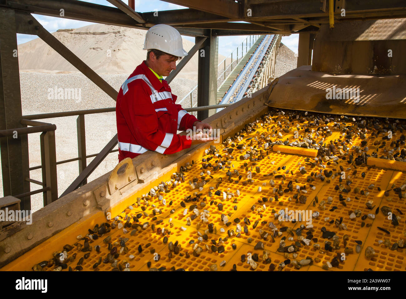 Voerde, Lower Rhine, North Rhine-Westphalia, Germany - Gravel plant, a processing mechanic monitoring the processing plant, here quality control on th Stock Photo