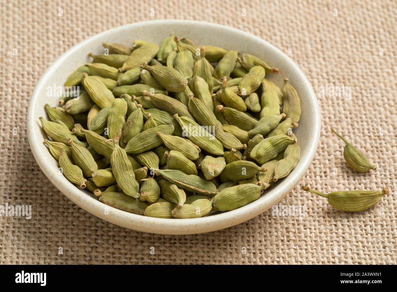 Bowl with green whole cardamom seed pods close up Stock Photo