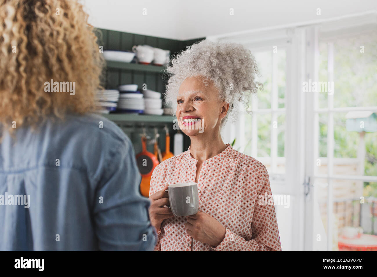 Senior adult woman having coffee with daughter Stock Photo