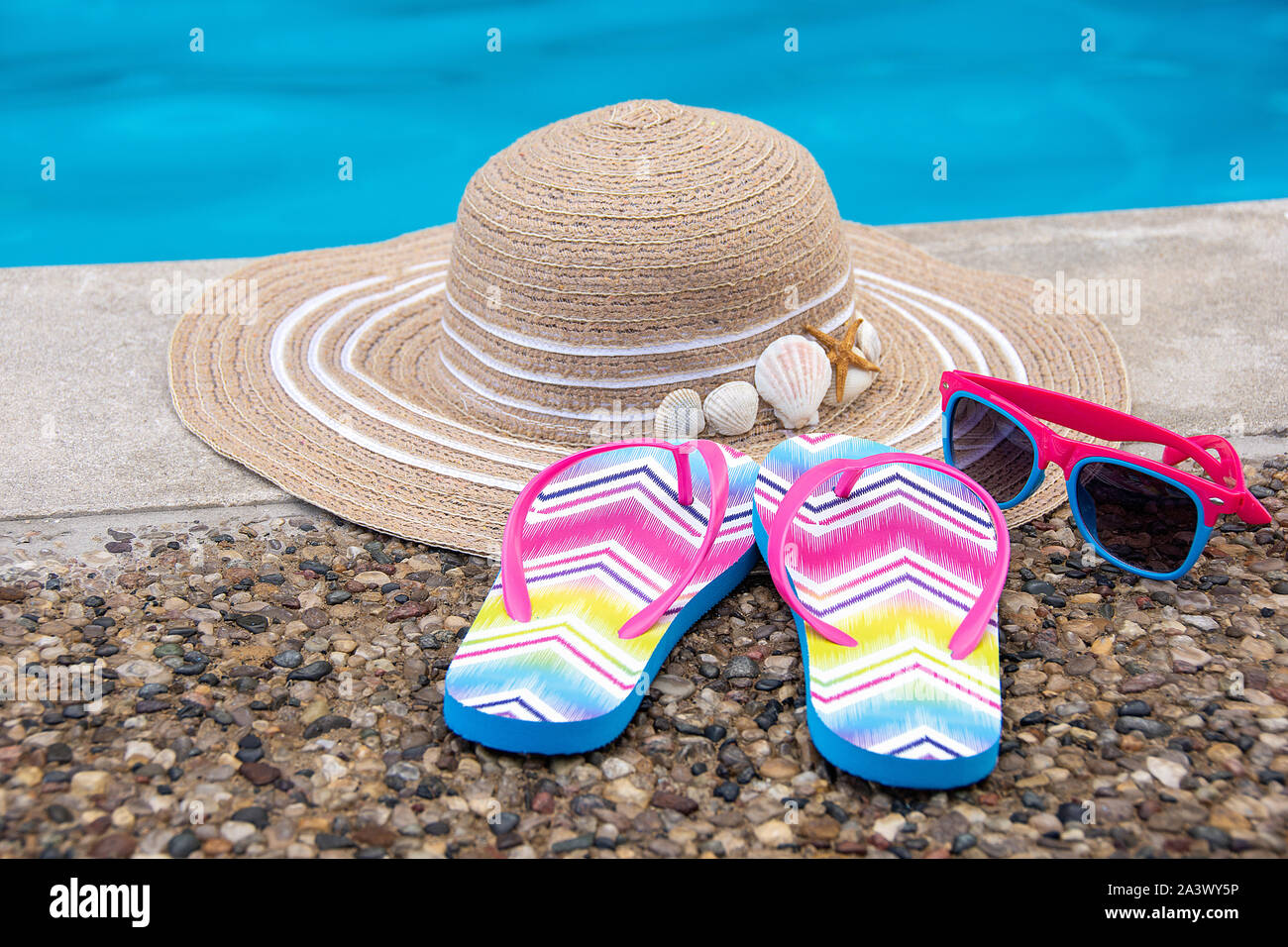 summer hat and flip-flops with sunglasses by swimming pool Stock Photo ...