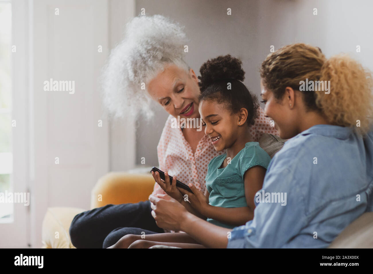 Granddaughter showing grandmother how to use smartphone Stock Photo