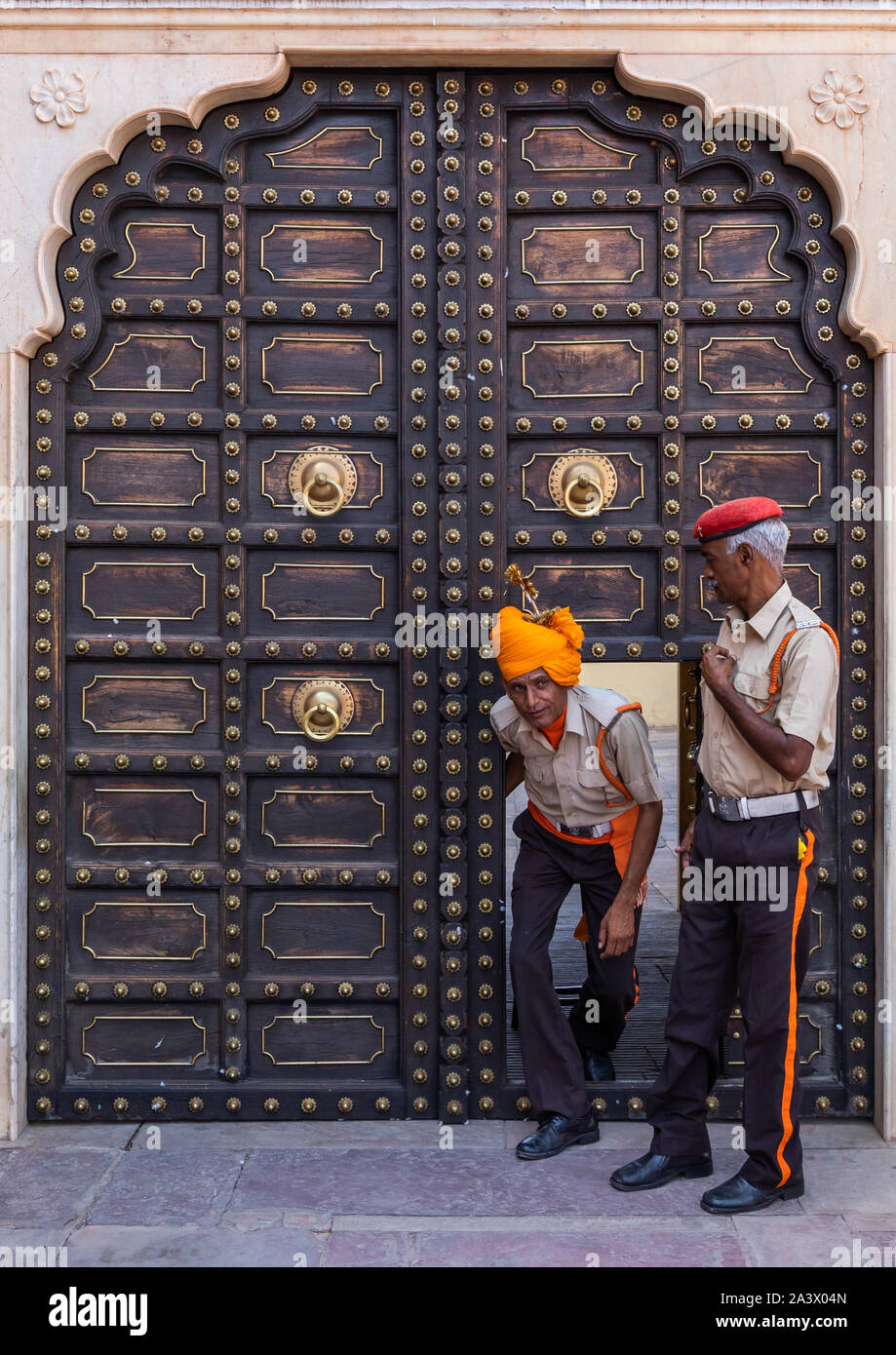 Indian guards in front of an old door in the city palace, Rajasthan, Jaipur, India Stock Photo
