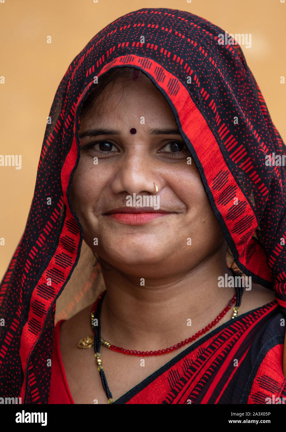 Portrait of a smiling rajasthani woman in traditional red sari ...