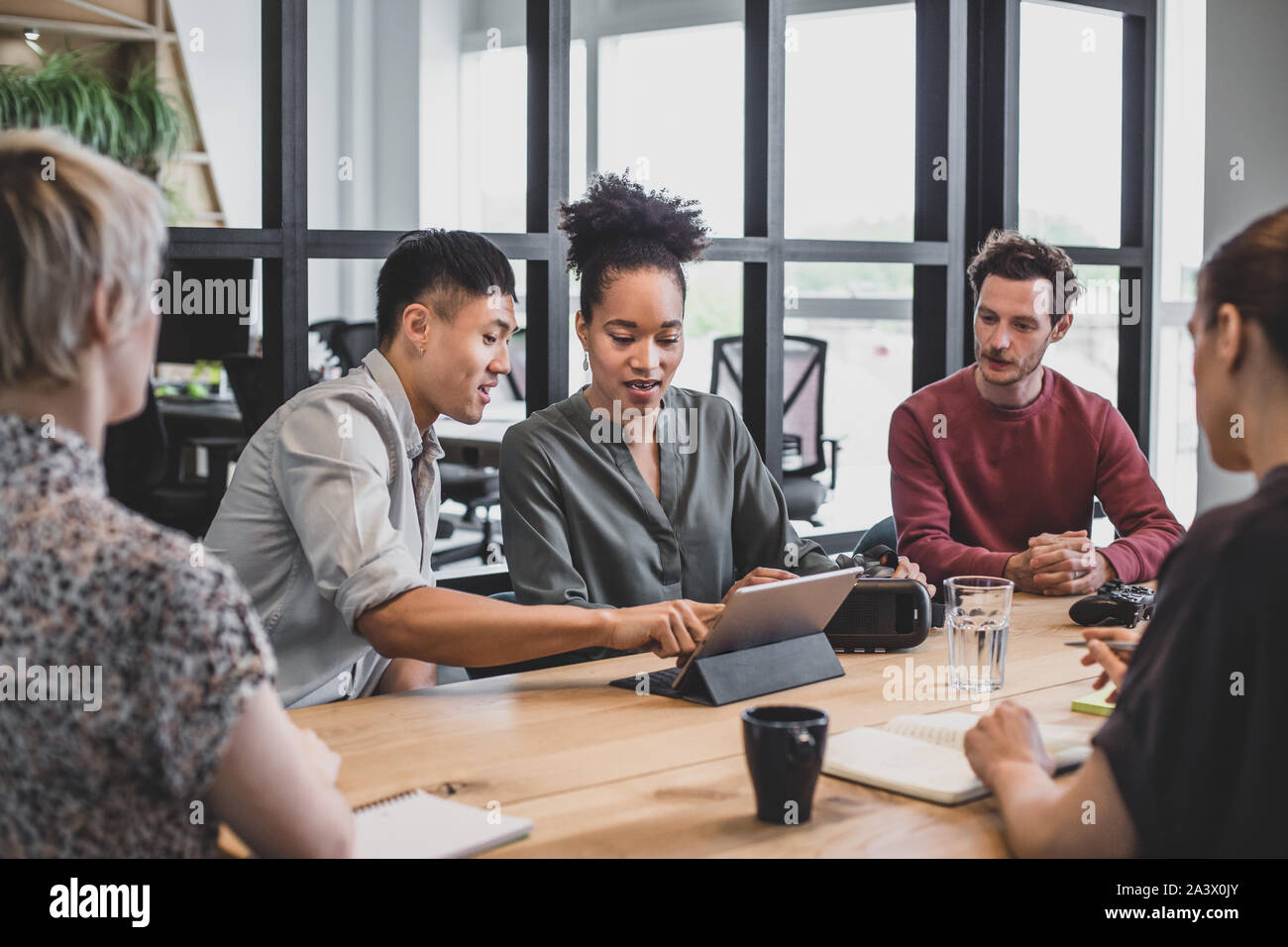 Coworkers in a meeting looking at a digital tablet Stock Photo
