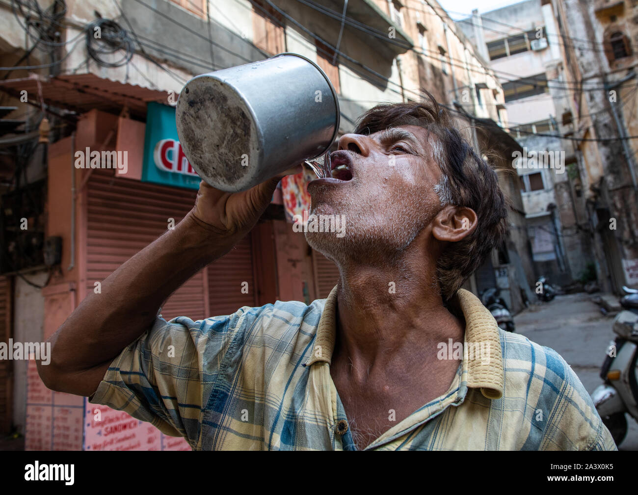 Indian man drinking in the street, Rajasthan, Jaipur, India Stock Photo