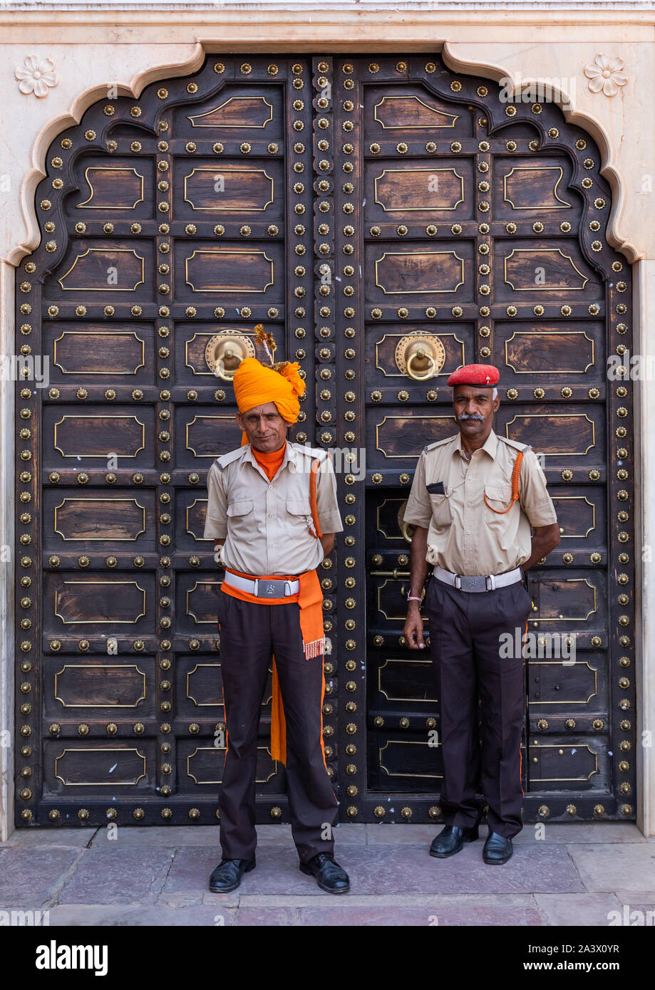 Indian guards in front of an old door in the city palace, Rajasthan, Jaipur, India Stock Photo