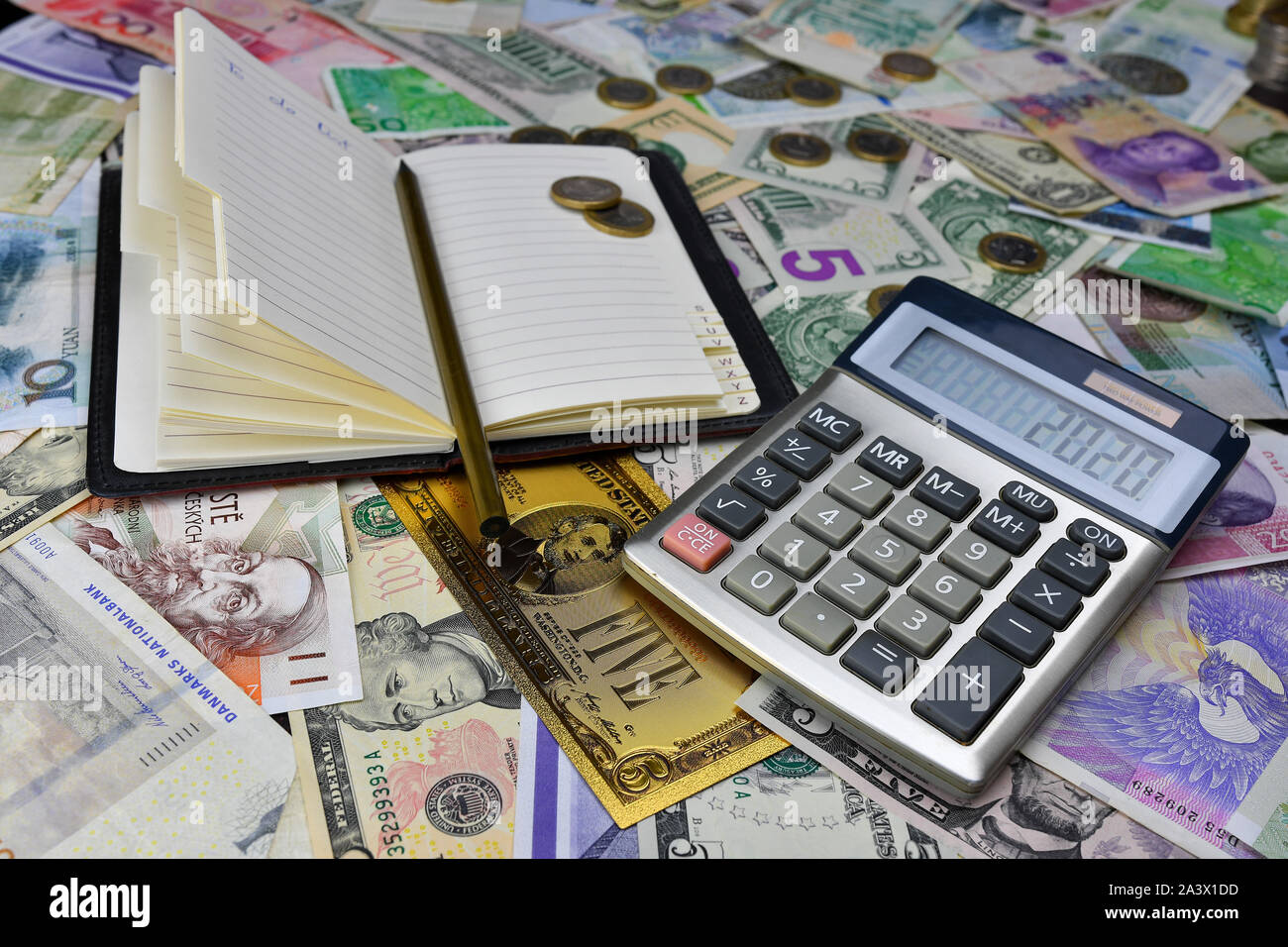Calculator, notebook and pencil on the background of different country  currency notes and one symbolic gold dollar banknote. Financial planning  conce Stock Photo - Alamy