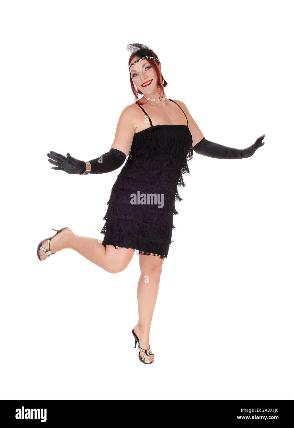 A gorgeous woman in a black dress of the 20 century and long cloves dancing in the studio, isolated for white background Stock Photo