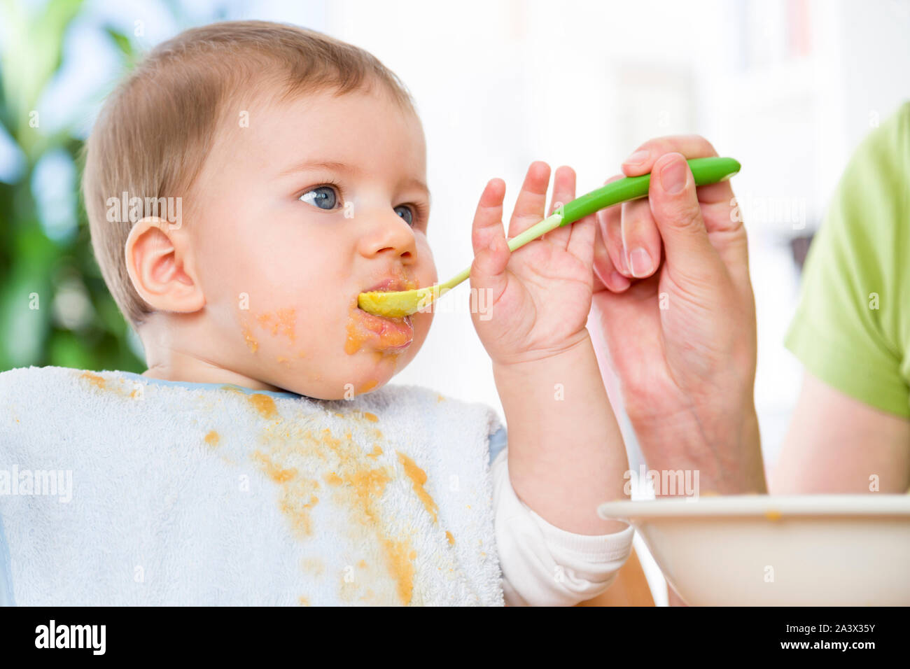 Close up of cute messy baby boy eating his meal. Stock Photo