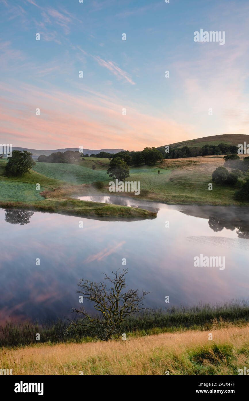 Early morning mist across Morton Loch at sunrise in september. Dumfries and Galloway, Scottish borders, Scotland Stock Photo