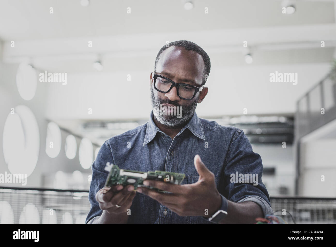 Closeup of African American adult male computer engineer holding motherboard Stock Photo