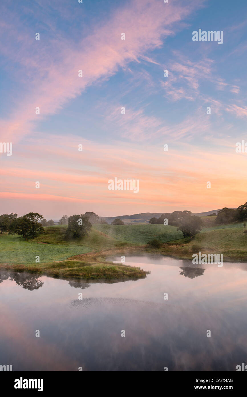 Early morning mist across Morton Loch at sunrise in september. Dumfries and Galloway, Scottish borders, Scotland Stock Photo