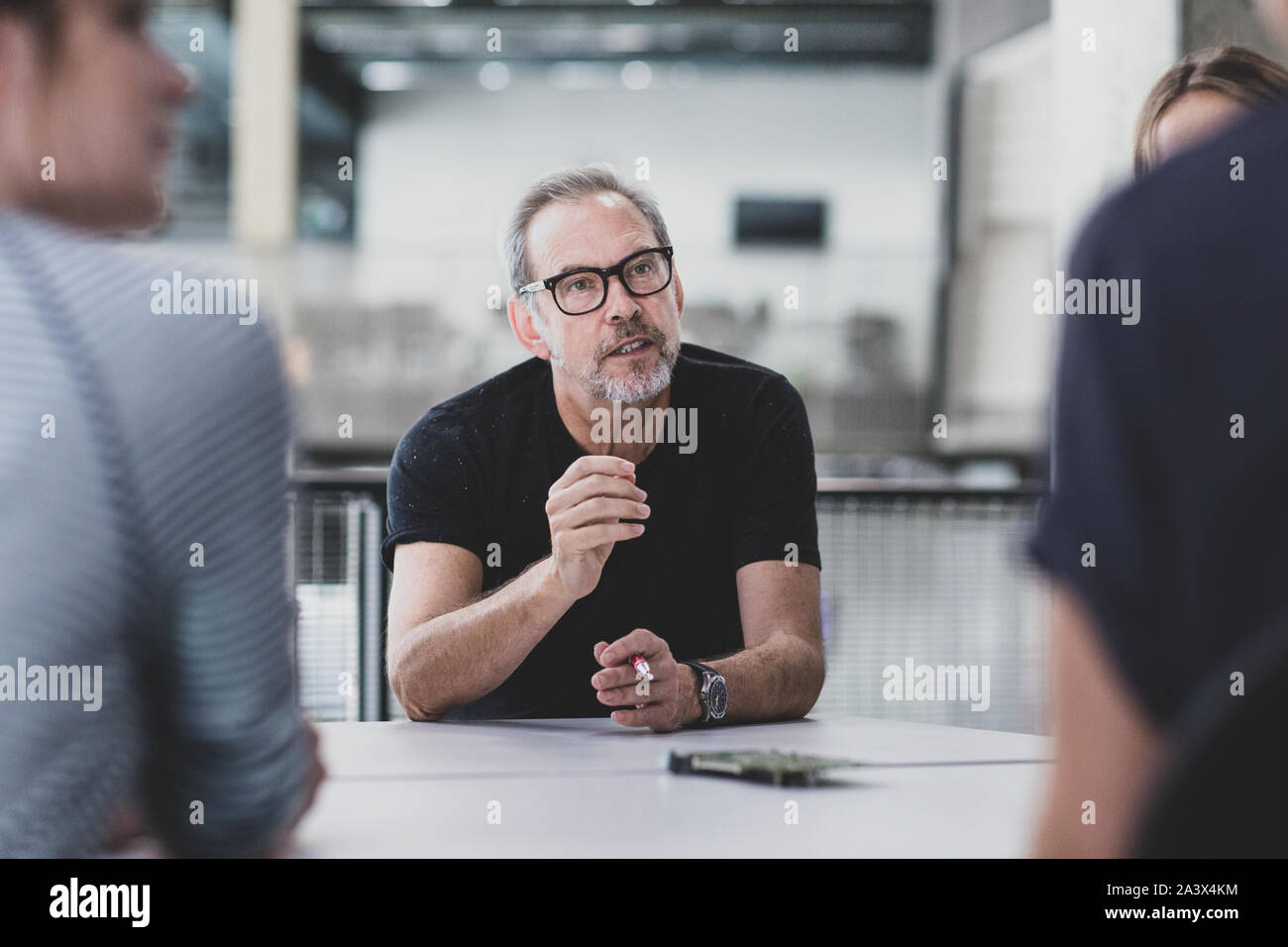 Mature adult male leading a meeting at a tech company Stock Photo