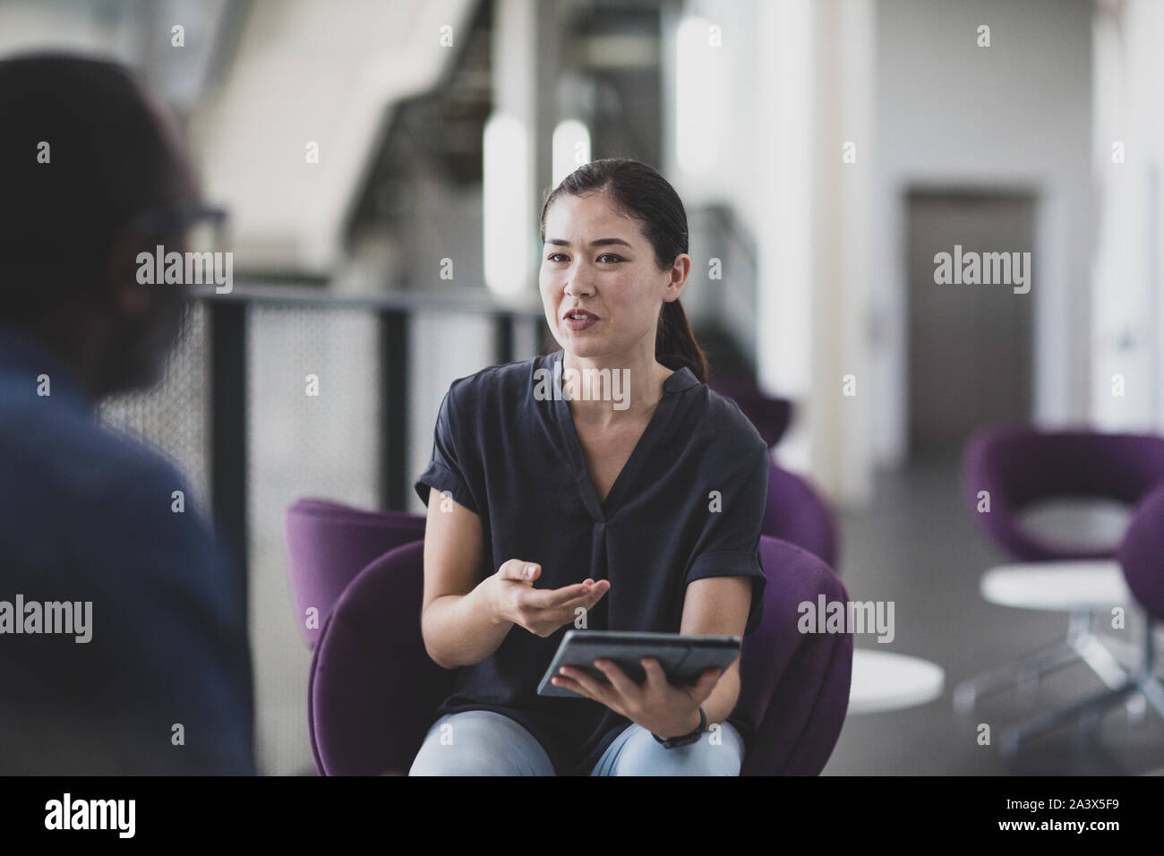 Businesswoman using a digital tablet in a meeting Stock Photo