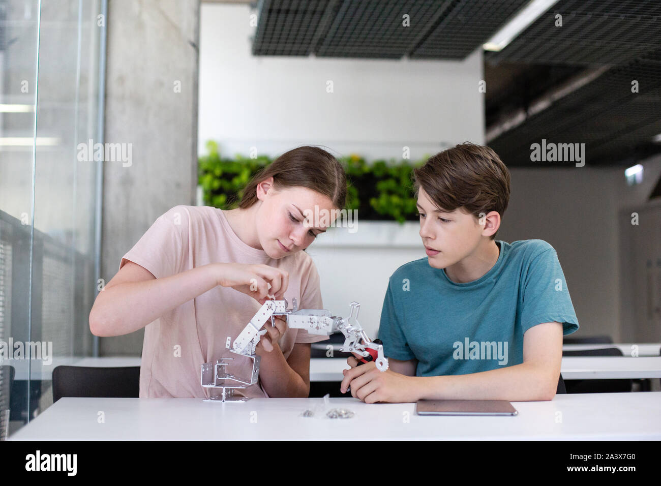 High school students working on a robotic arm in class Stock Photo