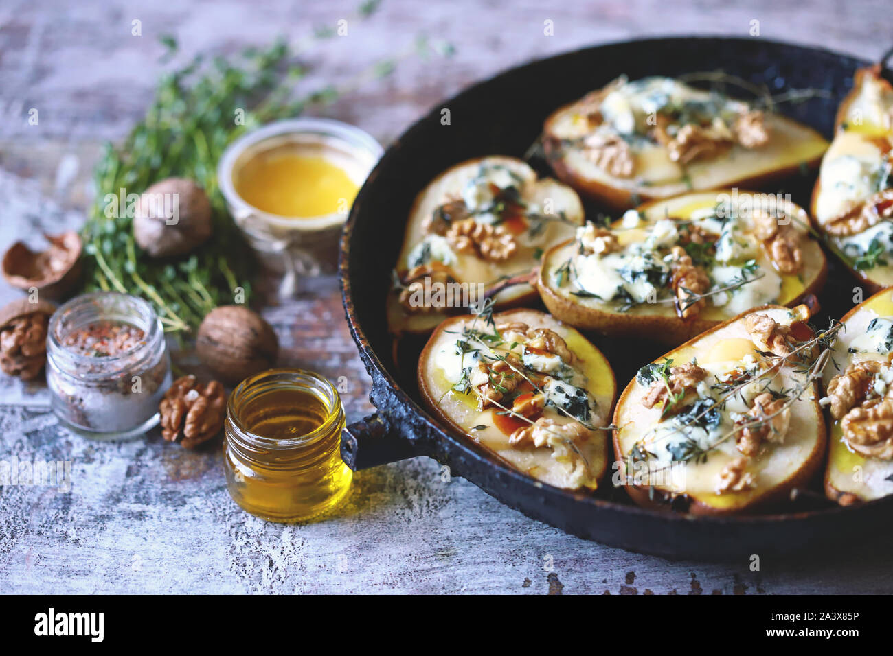 Baked pears with blue cheese, honey and herbs. French cuisine Appetizer to wine. Selective focus. Macro. Stock Photo