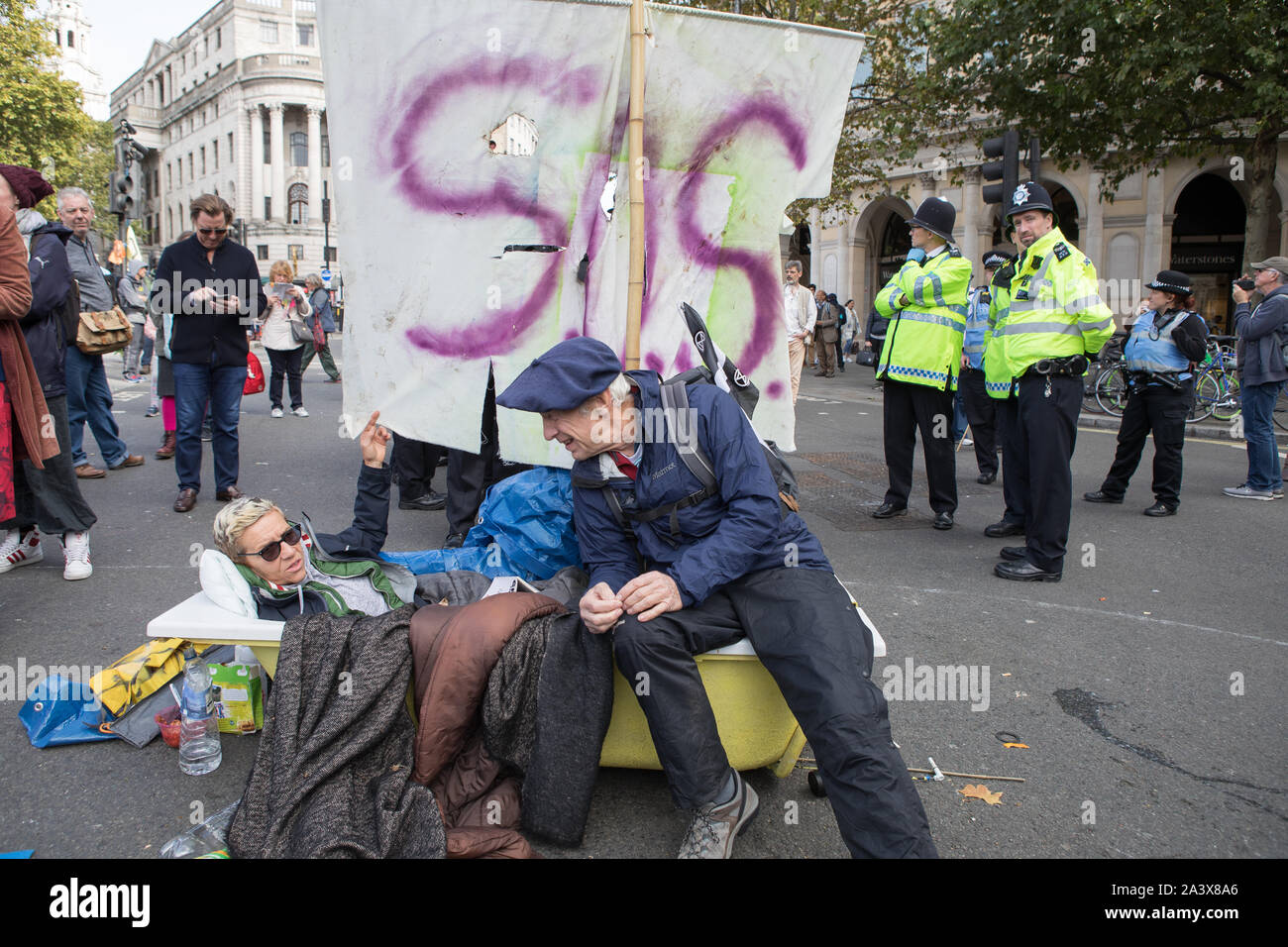 Westminster, London, UK. 10 October 2019. Environmental campaigners Extinction Rebellion have started two weeks protests from 7th to 20th October in and around London to demonstrate against climate change. A protester is glued on to a bath tub. The protesters in Trafalgar Square demand decisive action from the UK Government on the global environmental crisis. Stock Photo