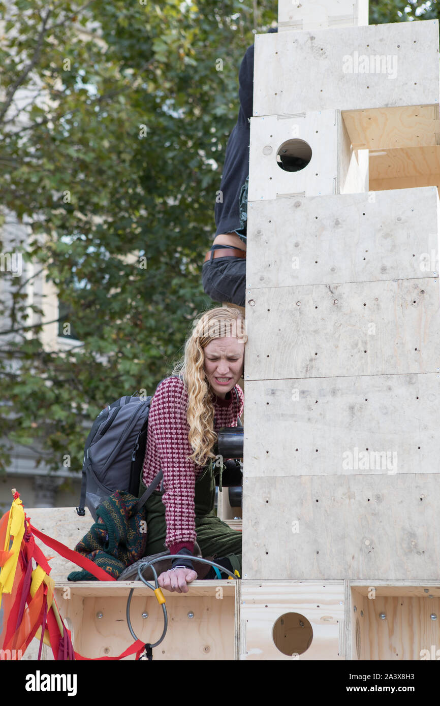 Westminster, London, UK. 10 October 2019. Environmental campaigners Extinction Rebellion have started two weeks protests from 7th to 20th October in and around London to demonstrate against climate change. A demonstrator is chained on to a wooden structure. The protesters in Trafalgar Square demand decisive action from the UK Government on the global environmental crisis. Stock Photo