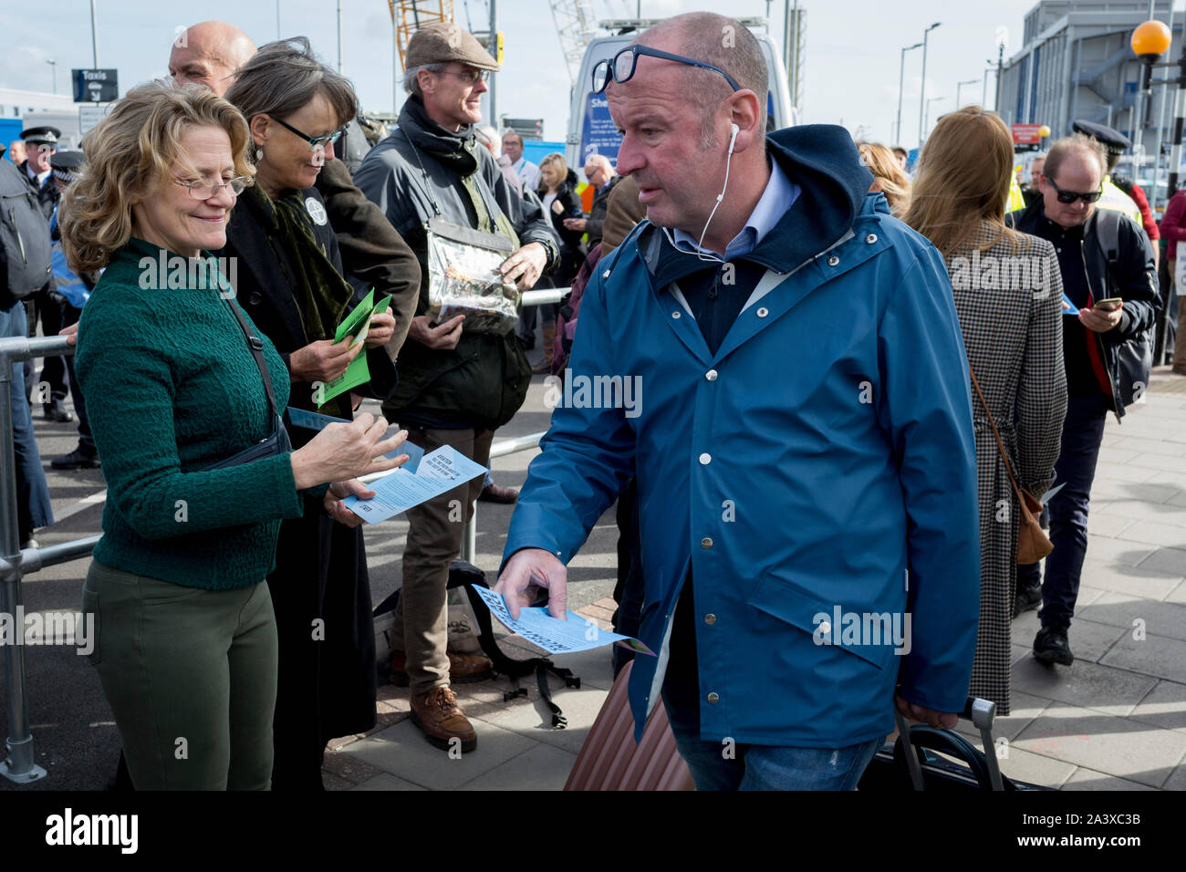 Environmental activists hand out leaflets to air passengers while protesting about Climate Change during the occupation of City Airport (London's Business Travel hub) in east London, the fourth day of a two-week prolonged worldwide protest by members of Extinction Rebellion, on 10th October 2019, in London, England. Stock Photo