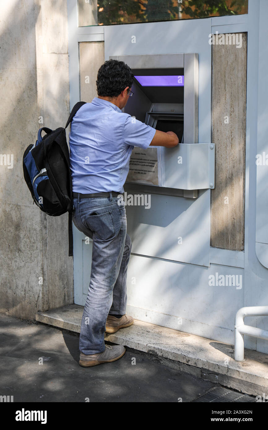 Man using ATM, automated banking machine, automated teller machine, automatic teller machine, bancomat, bankomat, cash dispenser, cash machine. Stock Photo