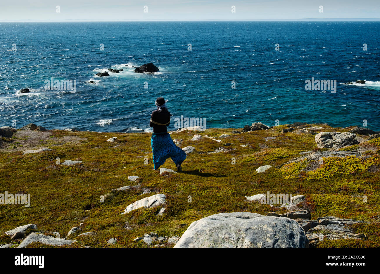 One woman looks out to sea from a cliff in Grates Cove, Newfoundland Stock Photo